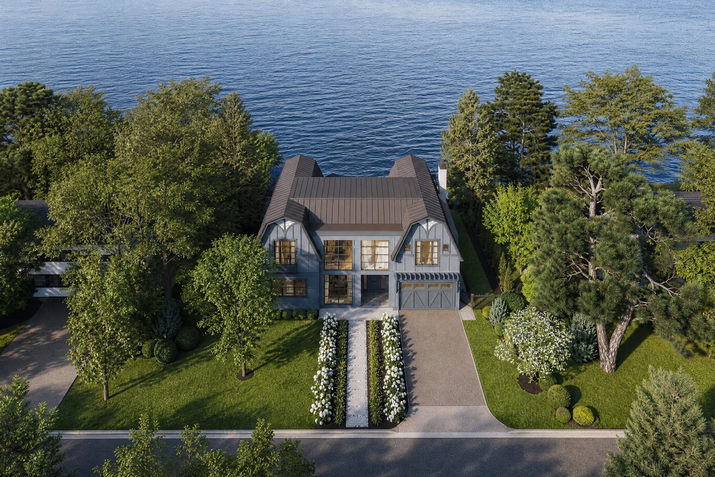 Aerial view of a Tudor Revival waterfront home in Bayville, NY, with its gambrel roofline set against the open lake